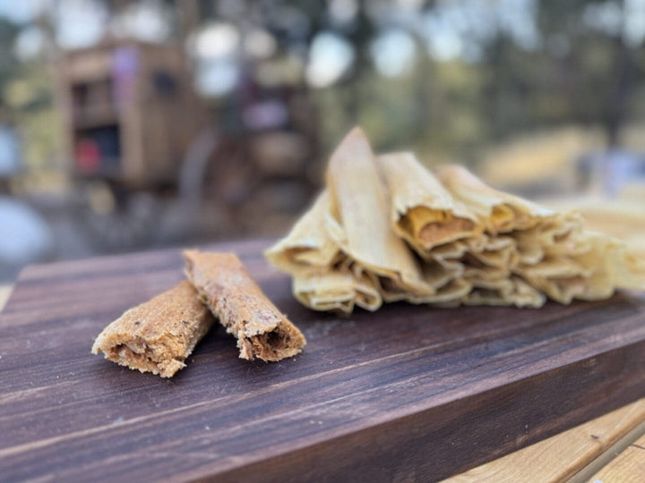 Tamales and mini tamales on wood board.