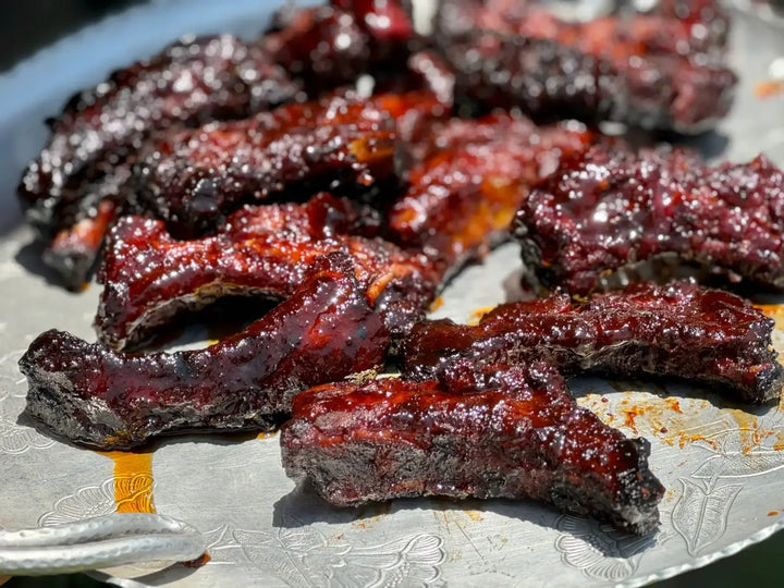 Glazed BBQ ribs on a tray.