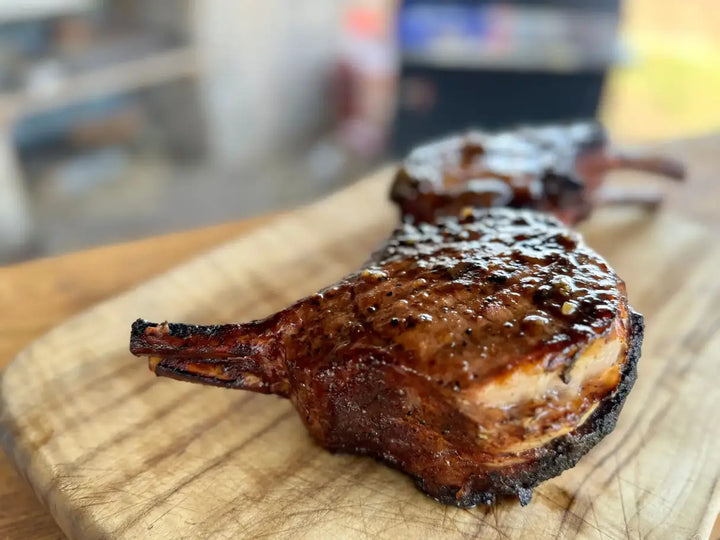Grilled pork chops on cutting board.